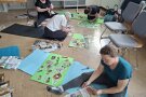 Personen sitzen auf Matten in einem Raum