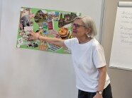 Frau deutet mit der Hand auf ein Poster