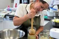 Frau stampft Sauerkraut in ein Glas