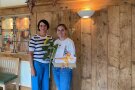 Eine Frau in einer weißen Bluse freut sich über die Urkunde. 