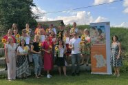 Viele Leute stehen mit Sonnenblumen auf der Wiese