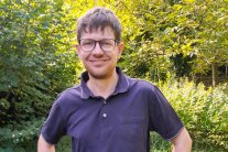 Mann steht im Wald